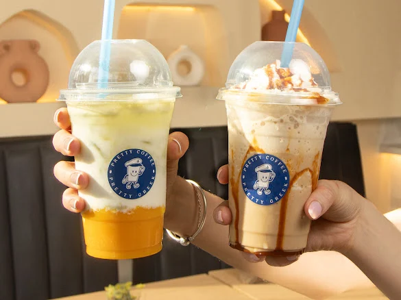 Dos bebidas heladas de Pretty Coffee con popotes azules